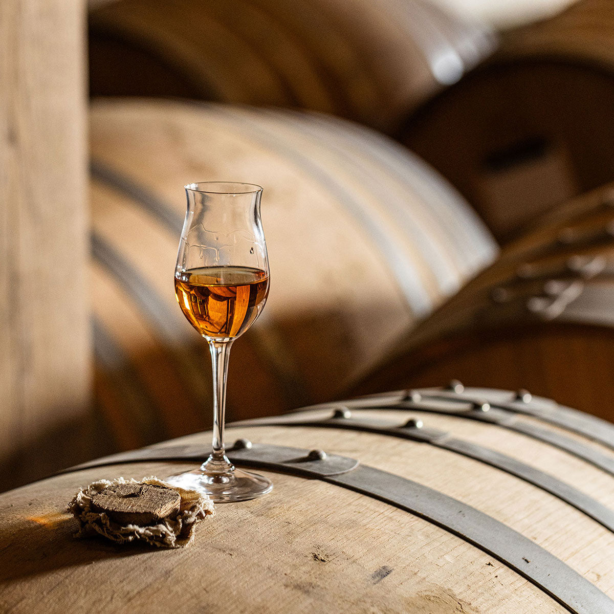 A Brandy glass over oak barrels