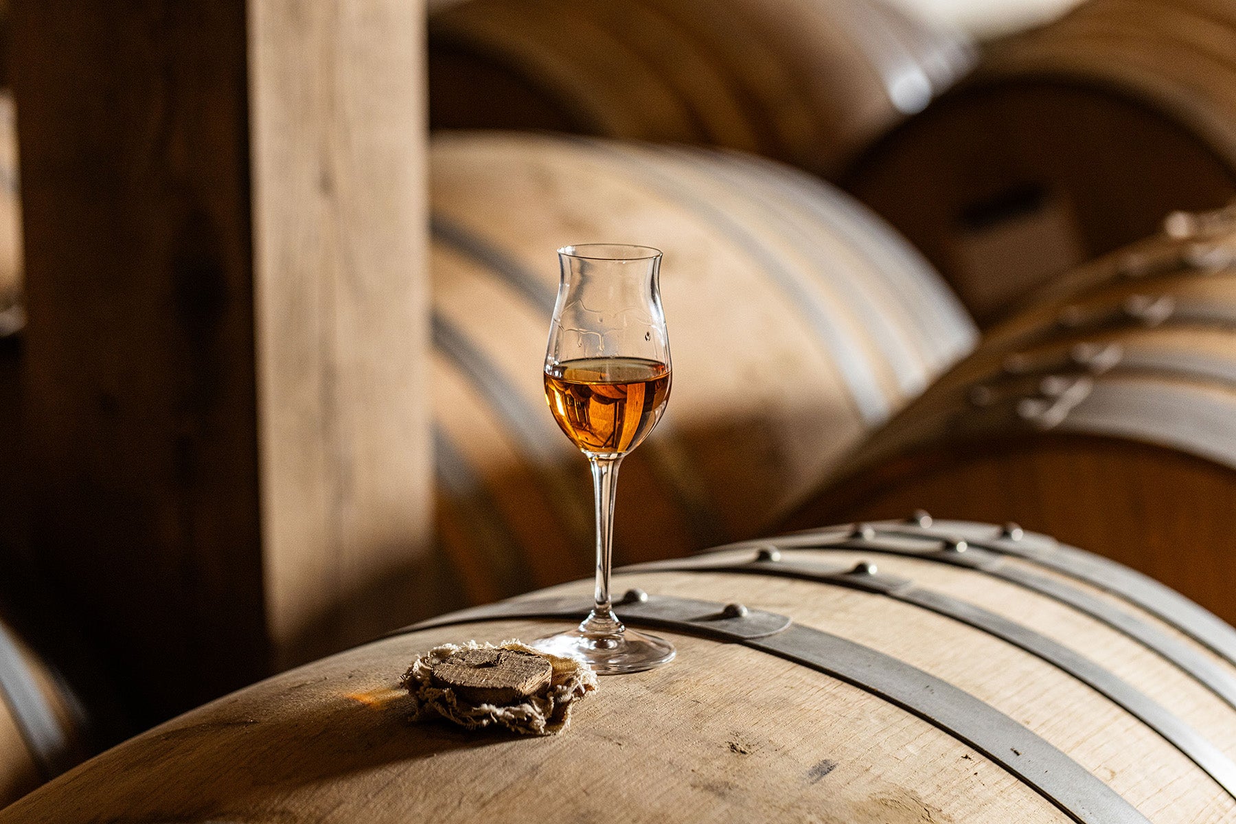 A bottle of brandy over an oak barrel